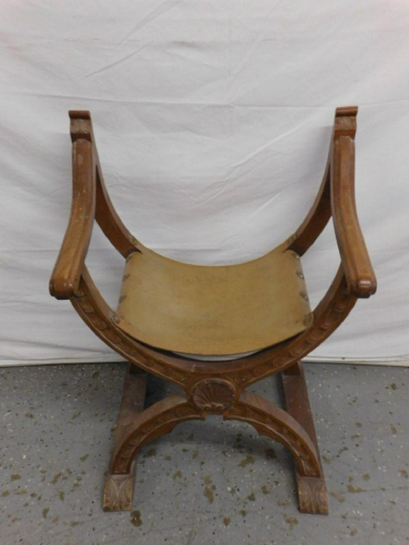 Gothic Style Dante Chair: Gothic Style Dante Chair, shaped arms, brass tacked leather seat foliate and fan carved walnut frame with shoe feet, early 20th C, 31"h, CONDITION: Very good, area with filled in tack holes; missing l