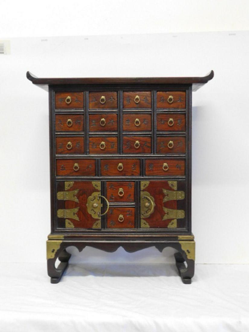 Chinese Spice Cabinet: Chinese Spice Cabinet, dark stained hardwood, features seventeen drawers and two doors, all with incised Chinese script, brass pulls and mounts, shaped apron and feet, 20th C, 25" x 9" x 21 3/4". COND