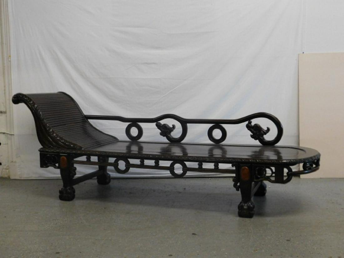 Chinese Chaise Lounge: Chinese Chaise Lounge, rosewood, features an "S" curved slat back, plank seat, ring and dragon carved back rail, and ring carved apron, ball and claw feet, 20th C, 29 1/2" x 82" x 28". CONDITION: Very