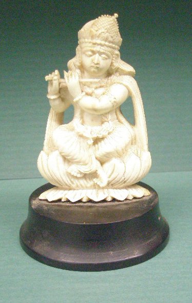 Ivory Carving of Indian Goddess w/Flute: Ivory carving of Indian goddess w/flute she sits upon a lotus blossom figure hgt 3", wood on base inscribed "Made in British India"...NO INTERNATIONAL SHIPPING...