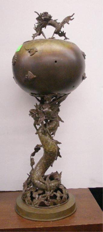 Chinese Bronze Covered Urn: Chinese Bronze Covered Urn, a melon form urn with sculptured dragon handle, applied bats & oriental character rest upon a large sculptured dragon on reticulated round base, hgt 28", approx diameter 10