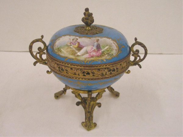 Sevres Covered Candy Box: Sevres porcelain & brass mount 7 1/4" x 6 1/2" covered candy box, hand painted artist signed scenic & courting scenes on lid, hand painted floral design in center of base, gilt enamel scroll design on