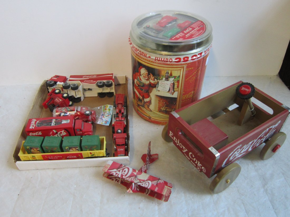 Lot Coca - Cola Collectible Items: Lot Coca - Cola Collectible Items including; Popcorn tin with sealed battery operated train set on top, tin hanging airplane, small (12") wood wagon and assorted diecast trucks and trailers. Condition