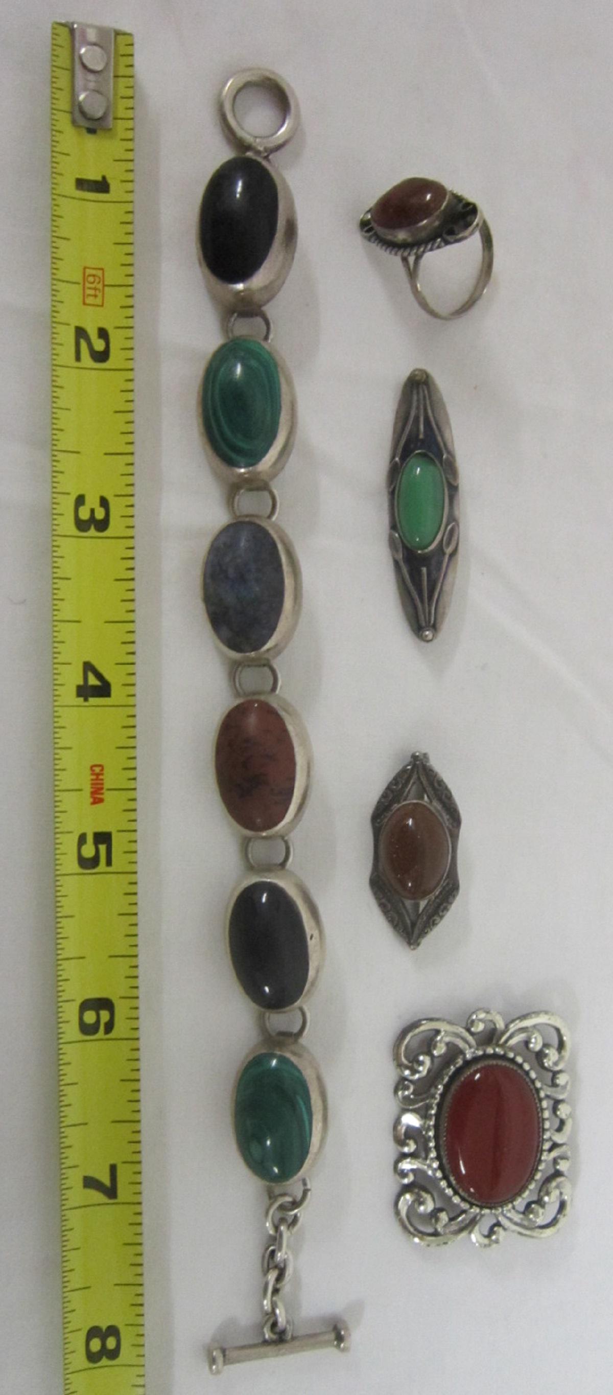Sterling & Semi Precious Jewelry Group: Sterling & Semi Precious Jewelry Group includes: 7" flexible bracelet with oval cabochon malachite and other stones, Mexico and amber stone, three pins with different colored stones.[15] CONDITION: Ve