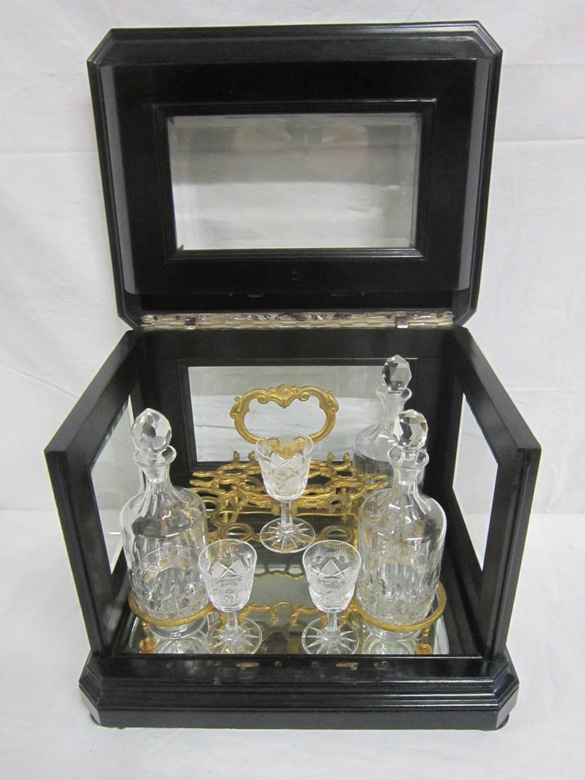 19th C Tantalus Box: 19th c Tantalus box, dark finished hardwood with beveled glass panels, fold back lift top, mirrored interior base and back, Dore bronze fitted stand holding three cut crystal 8 1/2" decanters and thre