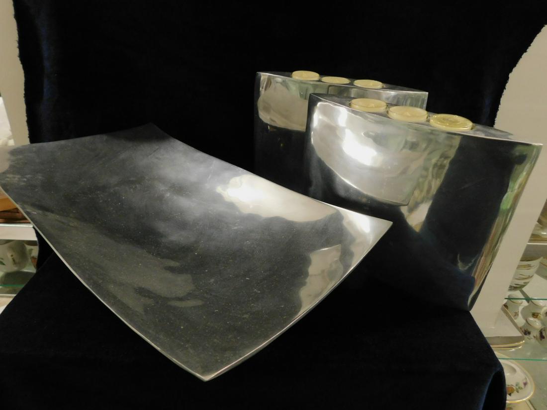 3 Escapade Aluminum Garniture: 3 Escapade Aluminum Garniture includes: labeled polished aluminum rectangular bowl on four raised brass ball feet,10" x 18 1/2" x 4", three light candle holders, 10' x 8" x 2", late 20th C. CONDITION: