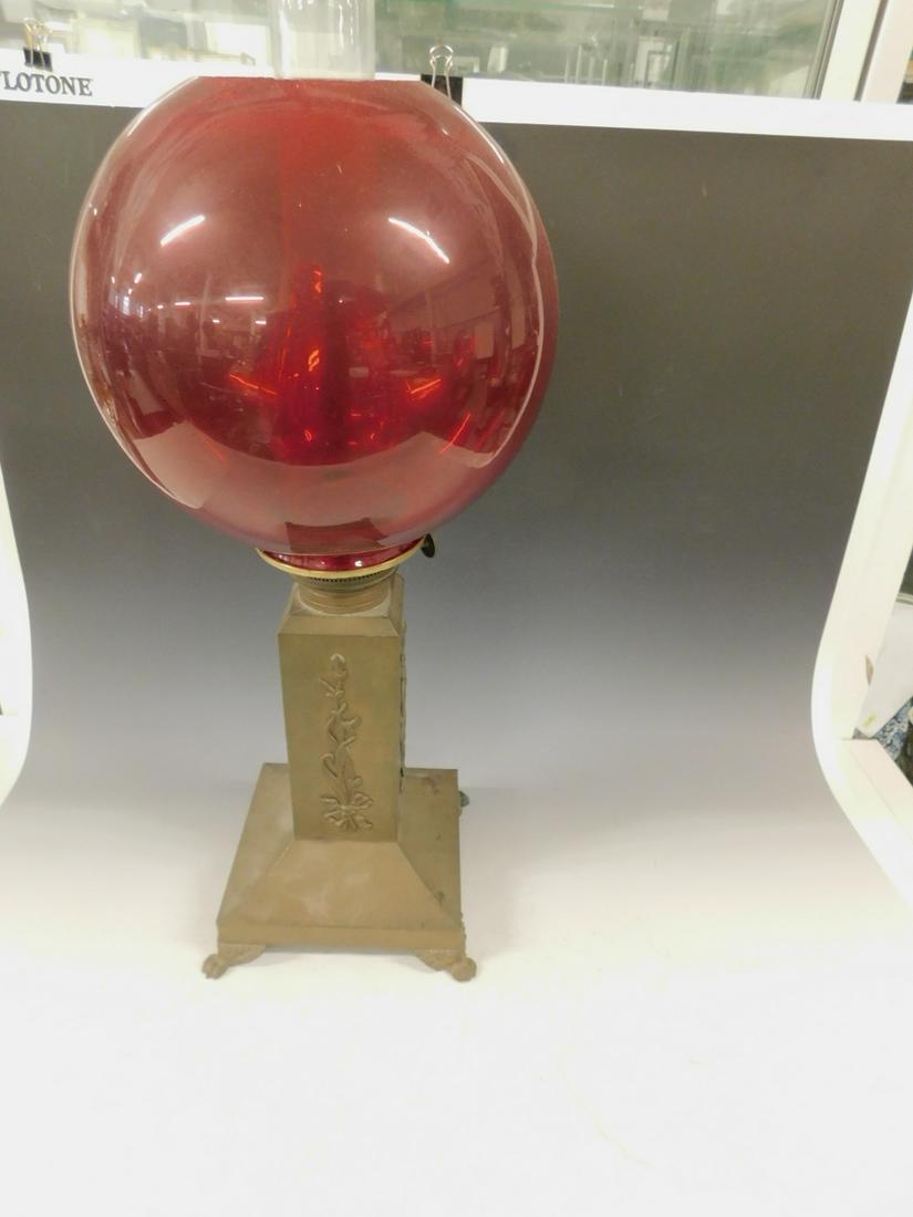Victorian Gone With The Wind Lamp: Victorian Gone With The Wind Lamp, brass square column with applied vines and ribbons on a conforming base with cast acanthus and claw feet, oil wick mechanism date 1890, ruby glass 10" d ball shade,