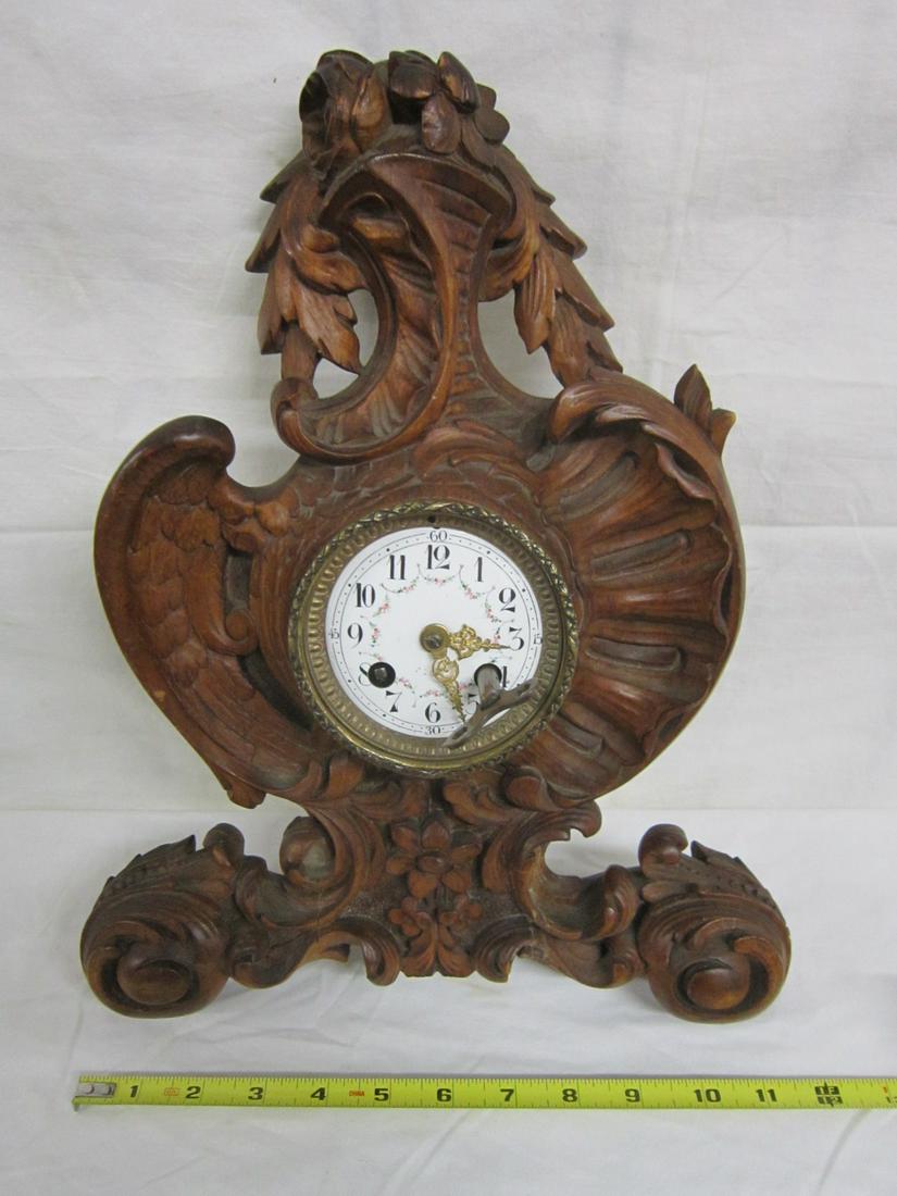 Black Forrest Type Wall Clock: Black Forrest Type Wall Clock, soft wood case with scrolls, flowers, shells and wing carvings; floral painted porcelain dial with brass time & strike movement, early 20th C, 12" x 14 1/2" x 3 1/2". CO