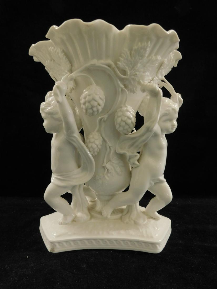 Copeland Spode Center Piece: Copeland Spode Center Piece, Blanc de chine porcelain; features a central vase flanked by three Putti holding vines of grape clusters, early 20th C, 9 1/4"h, 8"d. CONDITION: Very fine, small hair line