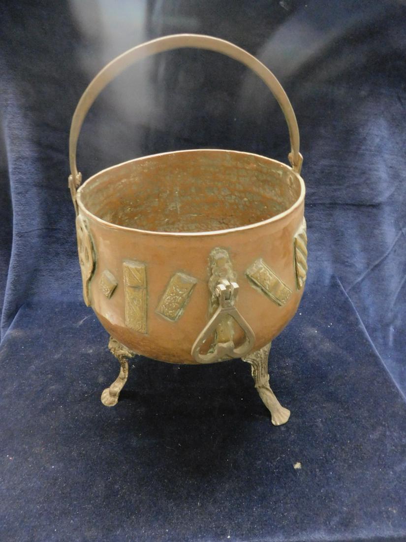 Mid East Cauldron: Mid East Cauldron, hand hammered heavy copper with wrought iron swivel handle, applied brass ornaments and side handles, all upon three textured cabriole type high legs, 19th / 20th c, handle up 14 1/