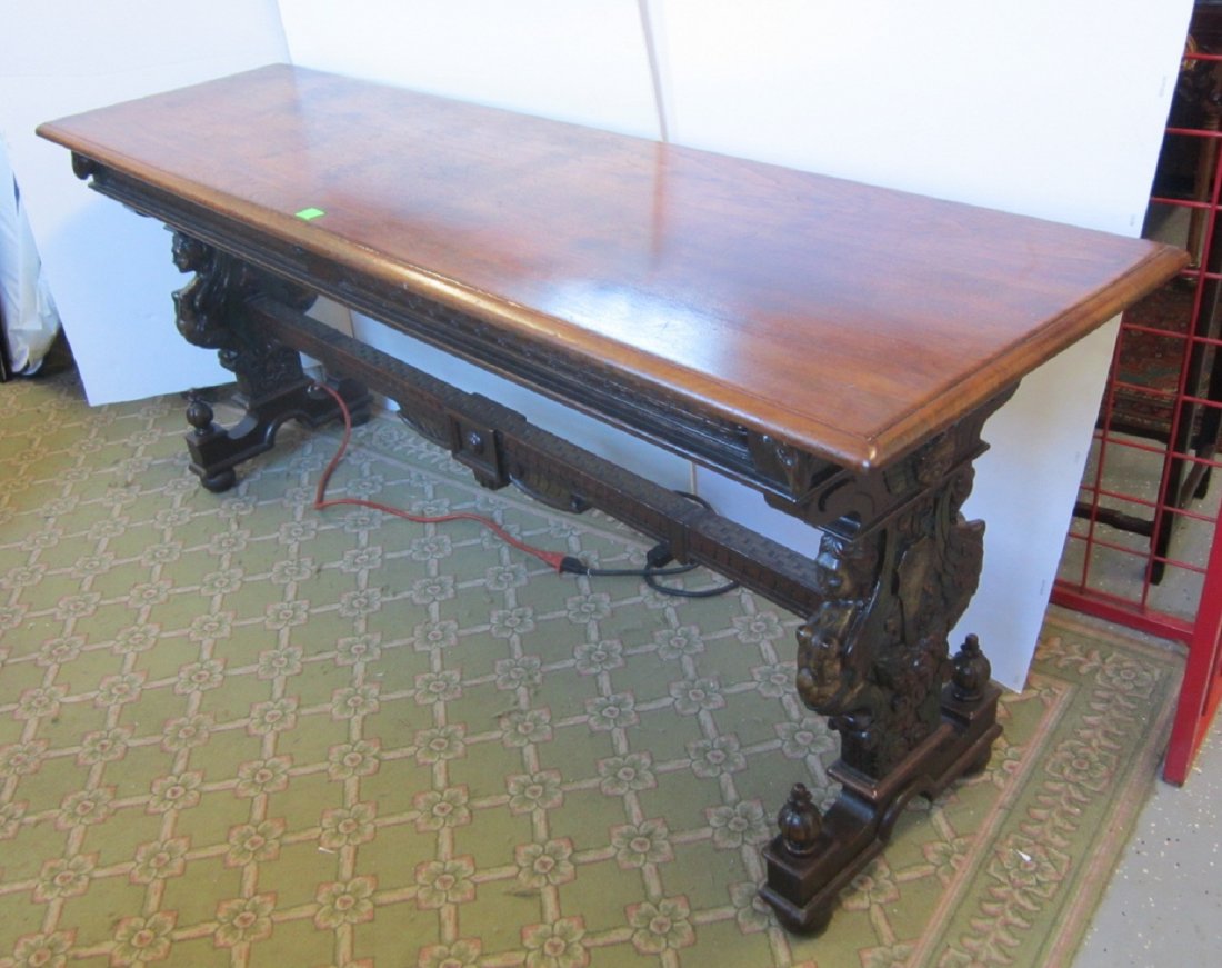 Renaissance Revival Library Table: Renaissance Revival Library Table, walnut, block relief carved frieze and stretcher on trestle type base with polychromed and carved caryatids, angel masks, urns and fruit; late 19th C, 72" x 20" x 29