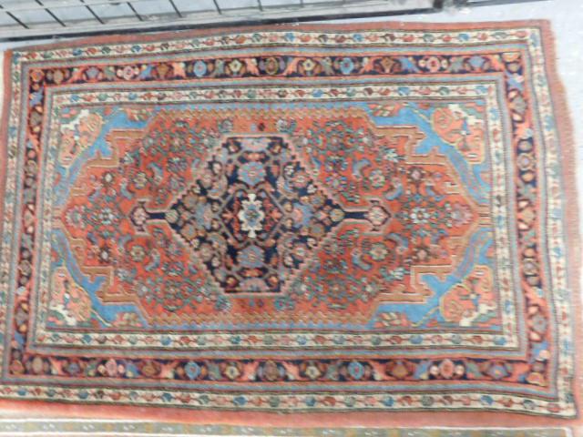 NW Persian Throw Rug: NW Persian Throw Rug, red ground with black central medallion, blues, beige and red spandrels and borders, early 20th C, 48" x 32". [7] CONDITION: Very good, some areas of border loss.