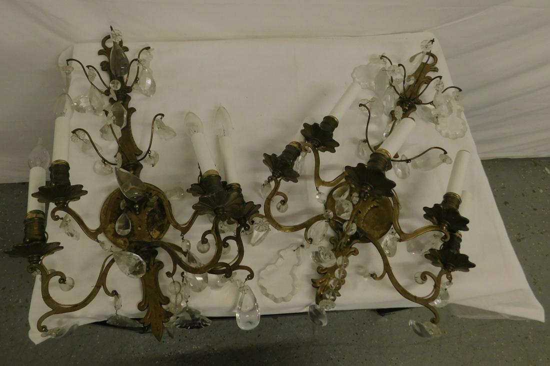 Pair Baroque Style Wall Sconces: Pair Baroque Style Wall Sconces, wrought brass shaped and grooved backs, five shaped arms with electrified candelabrum, overall pendant crystal drops of tear drops, shield rosettes and balls, early 20