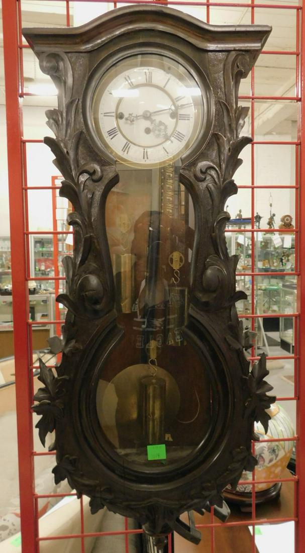 Vienna Regulator Clock: Vienna Regulator Clock, walnut black forest style leaf and scroll carved case, in stylized banjo form; porcelain dial with Roman Numerals, brass three weight key wind movement, late 19th C, 38" x 15" 