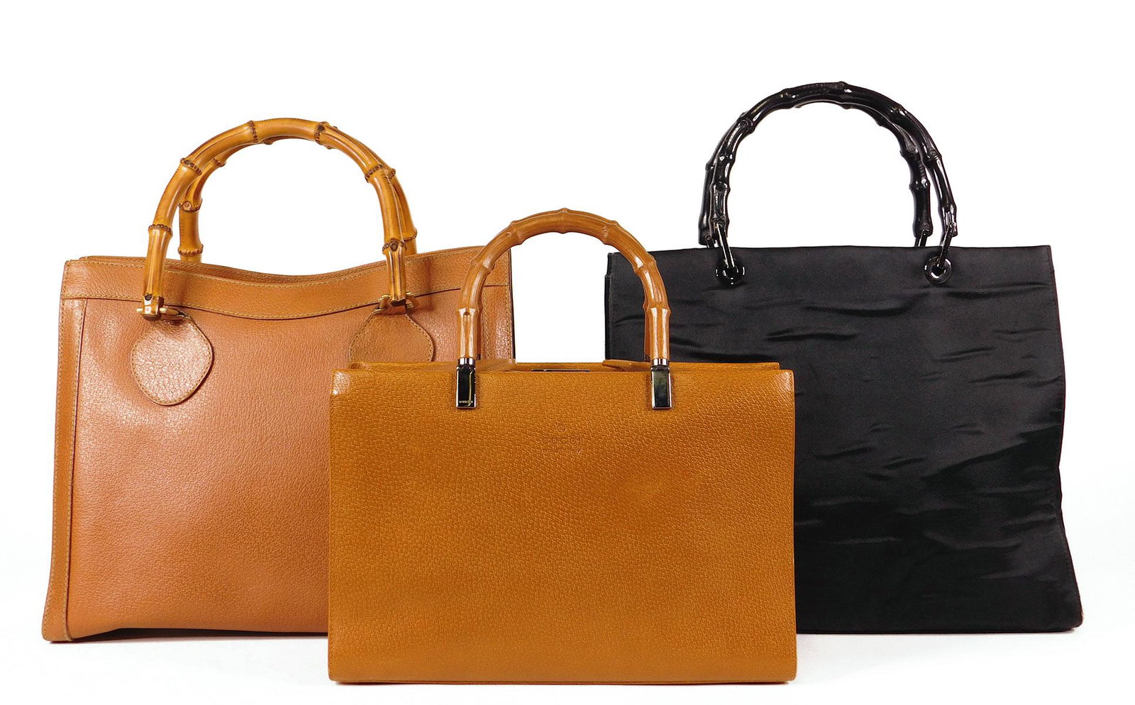 Three Gucci Bamboo Handbags: A Gucci rigid leather handbag with rigid molded bamboo-form handles and polished metal hardware. Double flap and latch closure, one open interior pocket, one zippered pocket. Included are a matching s