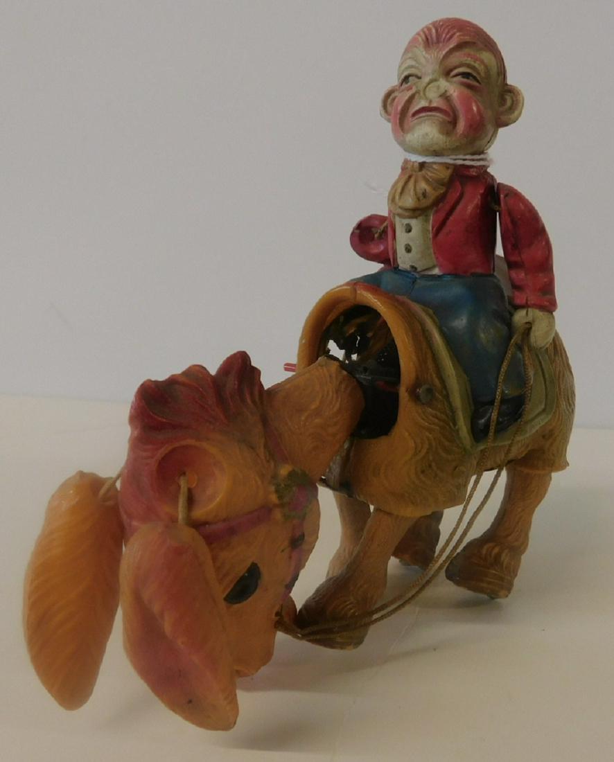 Celluloid Man on Donkey Mechanical Toy: Celluloid Man on Donkey Mechanical Toy, painted celluloid on metal frame with key wind movement, an angry man sits on a smiling donkey who walks and nods his head, circa 1930 - 40s, 6"l. CONDITION: Lo