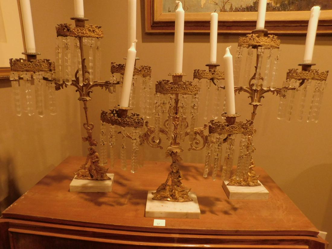 Victorian 3 Piece Garniture Set: Victorian 3 Piece Garniture set, Dore' brass, cast figures with 3 candle lights, cut crystal pendants on marble bases, circa 1860 -1870. 21" on tallest. Condition; good