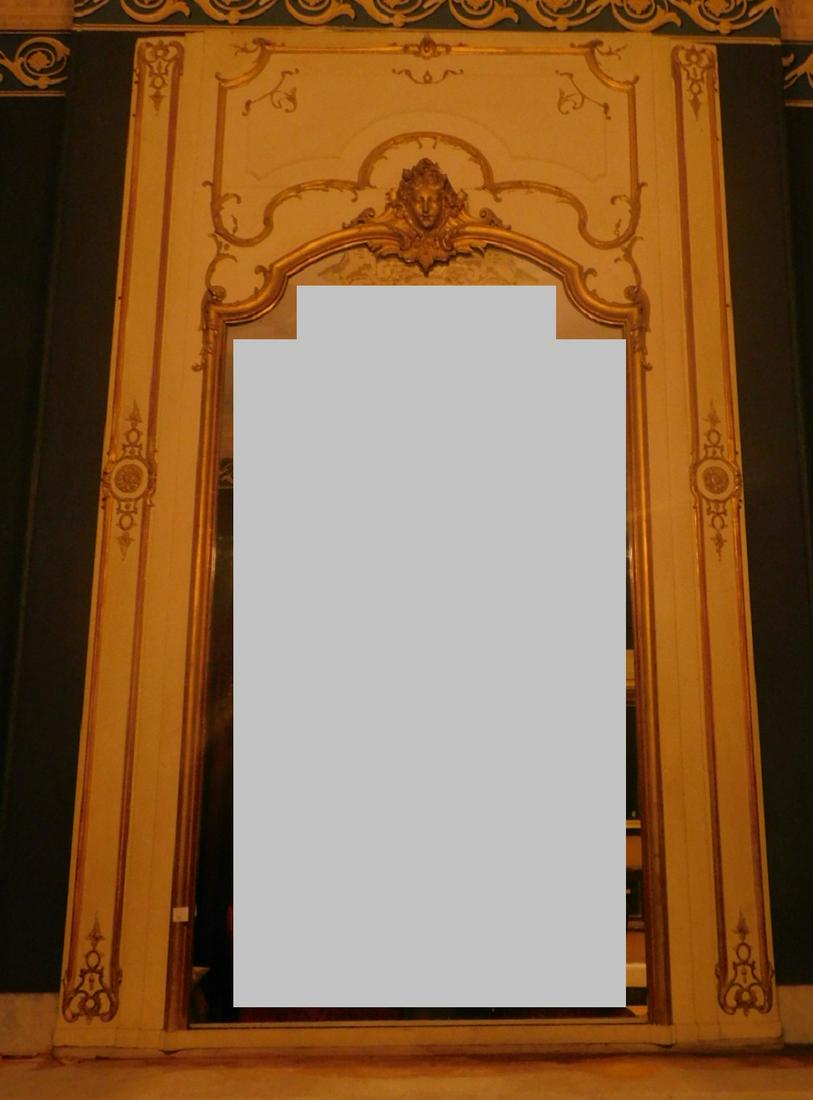 French Baroque Over Mantle Mirror: French Baroque Over Mantle Mirror, white painted with applied gilt scroll boarders, medallion finial mask Condition; slight gilt wear, boarder screws holding mirror, few areas of of mirror spotting