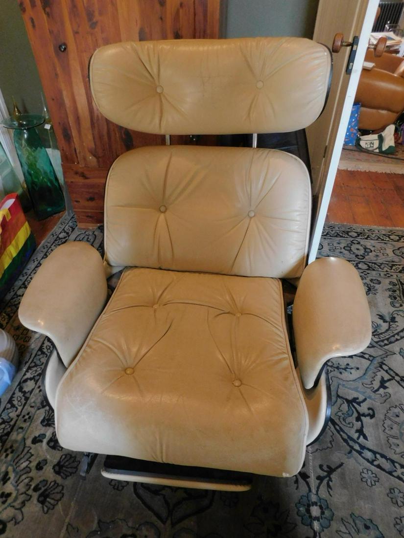 Eames Style Recliner: Eames Style Recliner, laminated wood with beige leather upholstery, fold under foot rest, 401/2" h. Condition; used, slight cracking to leather