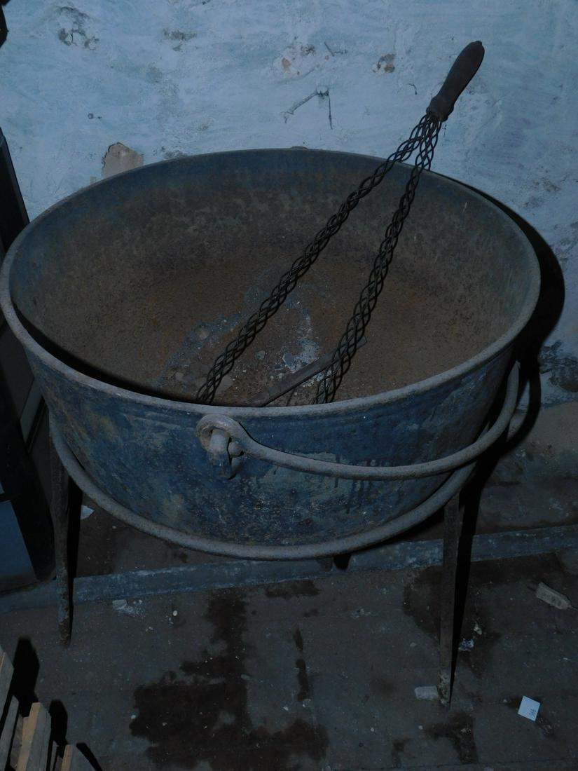 Cast Iron Witch's Caldron & Rug Beater: Cast Iron Witch's Caldron & Rug Beater, caldron, 24" diam. x 27" h with wrought iron rod handle and bar base, plus openwork metal rug beater with wood handle. Condition; normal wear from age and use