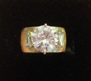 3 CT Round Diamond Ring: 3 CT round diamond ring, 14k yg Florentine finished 9.5 mm with band supports approx 3 ct round solitaire w/2 side tapered approx. 10 pt ea. baguettes, size 5, 5.5 DWT [3]