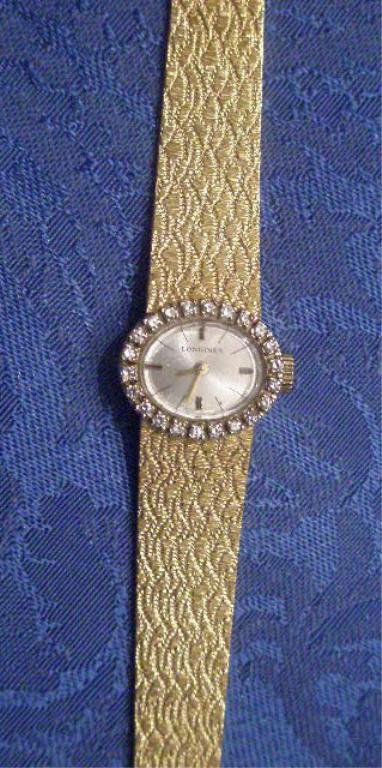 Lady's Gold Diamond Wrist Watch: Lady'd gold diamond wrist watch 18k Longines watch w/14k band 23.7 DWT, 6 7/8" length, oval watch case surrounded w/approx 1/2ct TW round diamonds. [28]