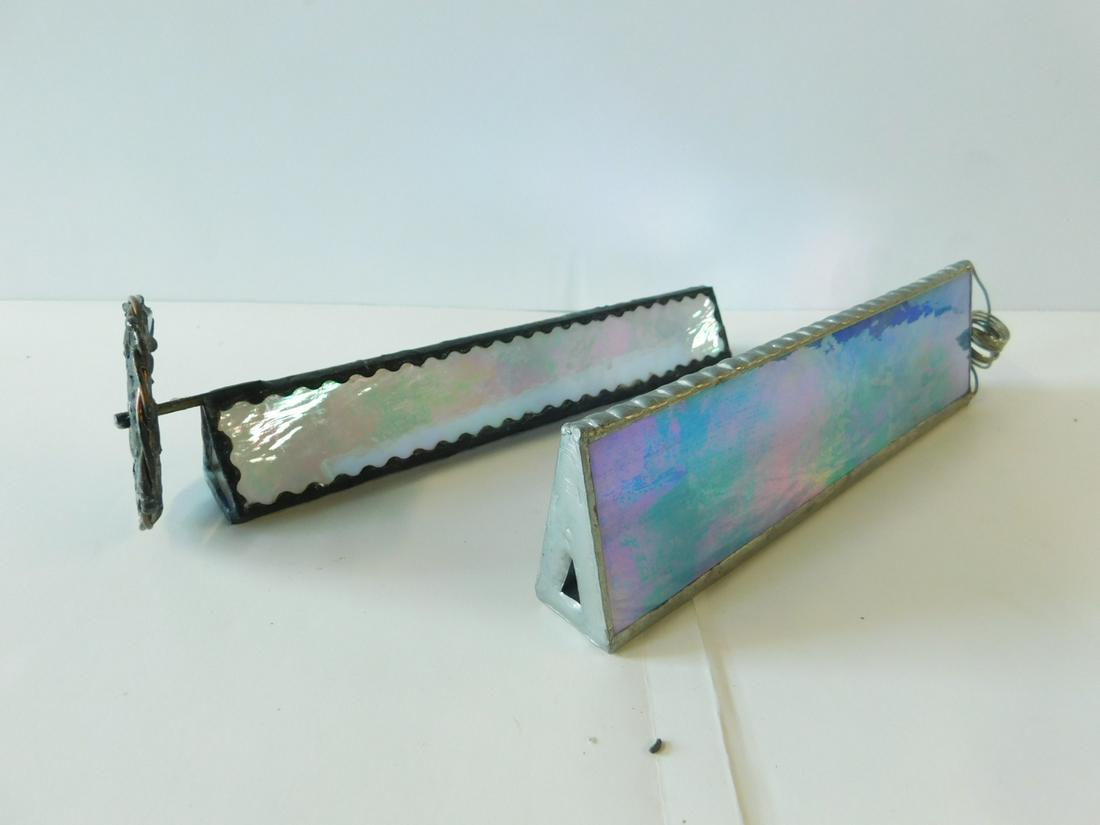 2 Iridescent Stained Glass Tri Kaleidoscopes: Two Iridescent Stained Glass Tri Kaleidoscopes, one has stained glass color wheel and one with glitter tube, 8" x 2 1/4"; 8 1/4" x 1 1/2", 2 1/2"d wheel. [6] CONDITION: Hand made, loose wheel.