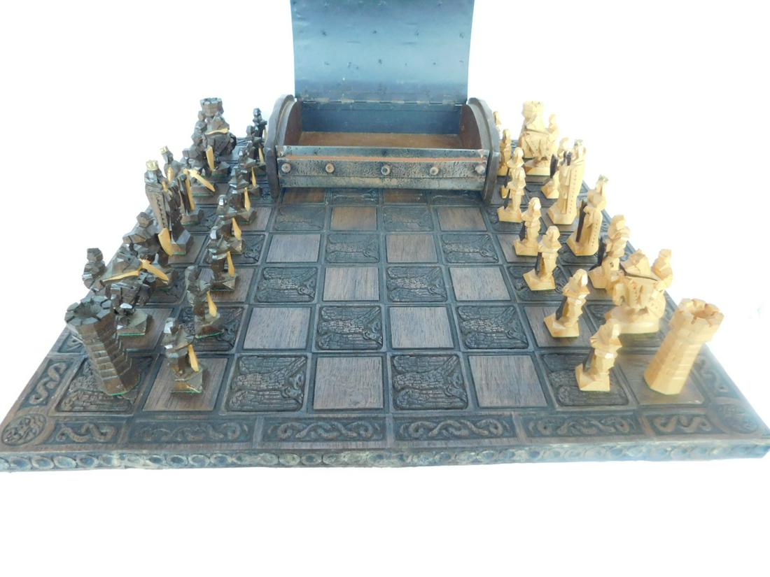 Carved Figural Wood Chess Set: Carved Figural Wood Chess Set, hand carved in soft wood in two tones, king height 3"; housed in a domed top strapped metal and wood box, includes: bird and entwined rope relief carved oak board, 18", 
