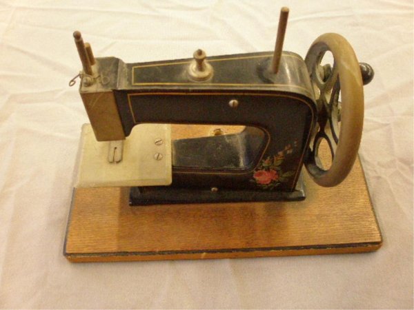 1930's Child's Toy Sewing Machine: 1930's painted cast metal child's toy sewing machine mounted on wood baseq