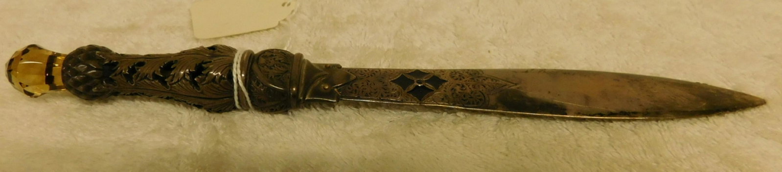 Scottish Silver Letter Opener: Scottish Silver Letter Opener, reticulated thistle and leaf handle with cut amber crystal crest finial; scroll engraved and florentine blade with touch marks and black enameled cartouche, 19th / 20th 