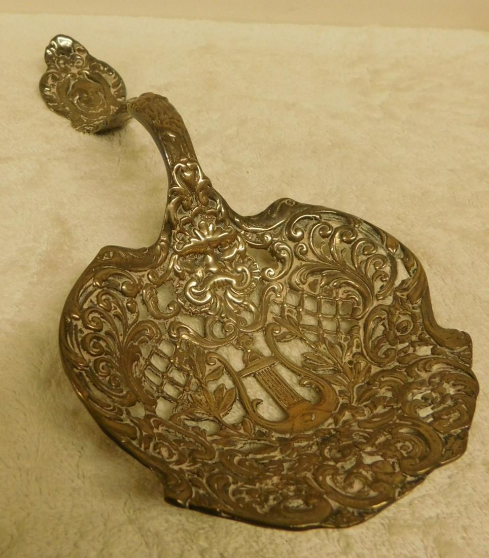 Sterling Silver Fancy Serving Spoon: Sterling Silver Fancy Serving Spoon, overall reticulated and repousse with mask, lyre and scroll motifs, early 20th C, 10 3/4"l, 9.43 ozts. CONDITION: Good, with areas of wear and tarnish.