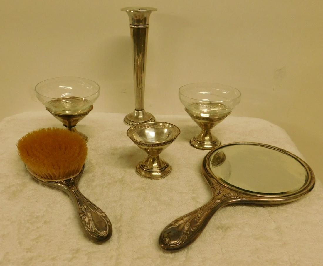 Sterling Silver Grouping: Sterling Silver Grouping includes: weighted 7" trumpet form bud vase, three solid sterling sherbet bases, two with glass inserts, and a floral embossed hand mirror and brush set. CONDITION: Some tarni