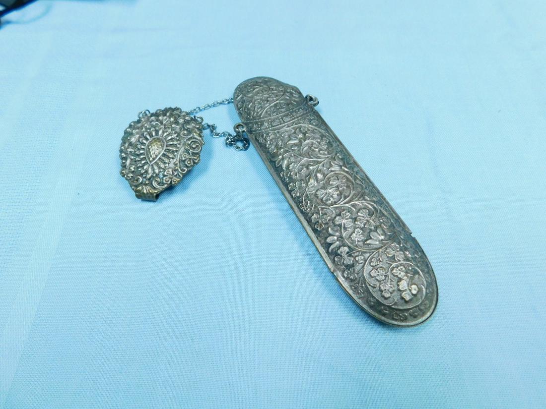 Victorian Chatelaine: Victorian Chatelaine, repousse silvered metal with vine, floral and avocado motifs, features a belt clip and a chain suspended eye glass case, 6"l, overall 10 3/4"l, late 19th C. CONDITION: Tarnished.