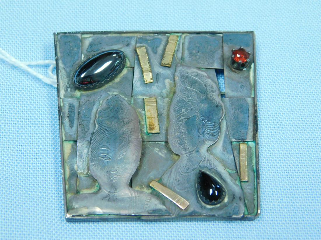Modernist Thorpe Sterling Brooch: Modernist Thorpe Sterling Brooch, Asian relief, faces, gold wash embellishments, in trapezoid setting, marquise hematite, pear shaped black onyx and round garnet stone, signed Thorpe, 1989, sterling L