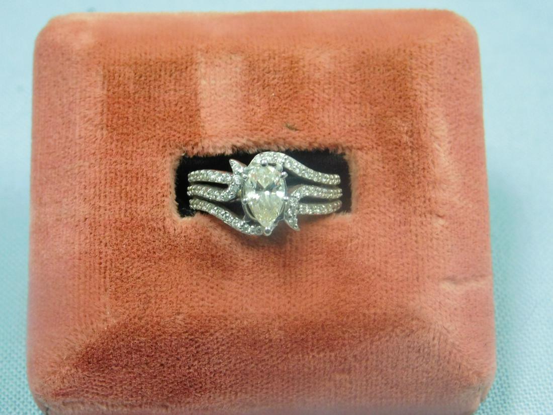 14k WG Pear Shaped Diam. Ring: 14k WG Pear Shaped Diam. Ring, approx. 3/4 ct ps, surrounded with swirled mounting of accent diamonds, size 5, 2 DWT.[13] CONDITION: Very good, diamond is yellow in color.
