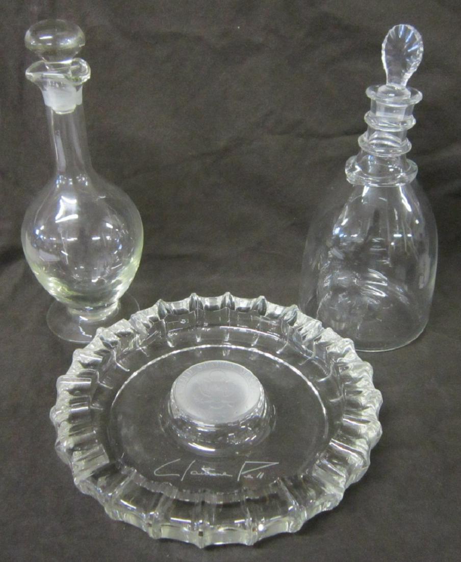 2 Crystal Decanters & Senate Dish: Two Crystal Decanters and Senate Dish, two blown glass crystal decanters, both with stoppers including: footed, 11" and ring neck, 10 3/4", plus souvenir cigar ashtray, etched signed Claiborne Pell (S