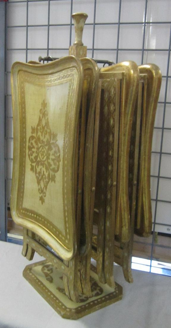 Italian Nest of TV Tables: Italian Nest of TV Tables, central column with brass rod supports four folding tray tables, heavy gilt decorations, circa 1950s-60s, 34" x 14" x 10". CONDITION: Very good, gilt wear.