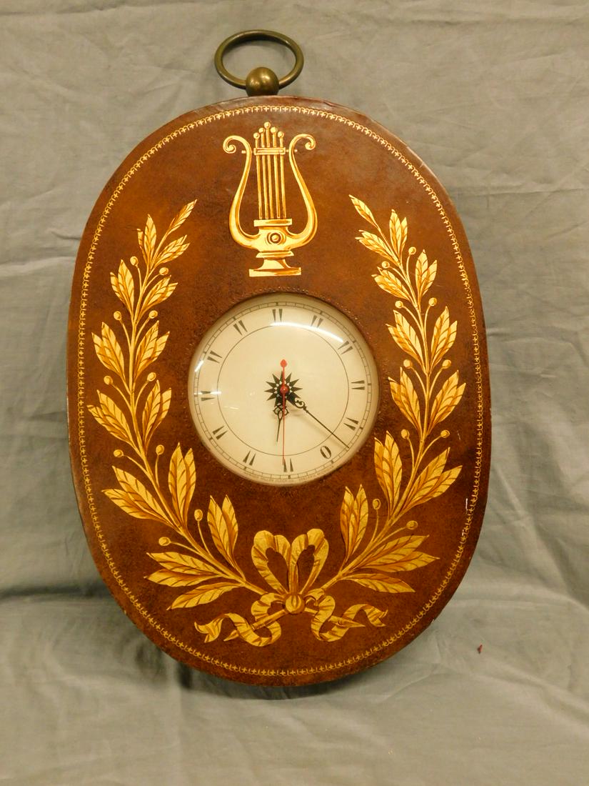 Designer Wall Clock: Designer Wall Clock, tooled leather covered oval shape electric clock with brass ring crest handle, circa 1930-40, 18 1/2" x 11" x 3 1/4". CONDITION: Very good, minor wear, working cond.