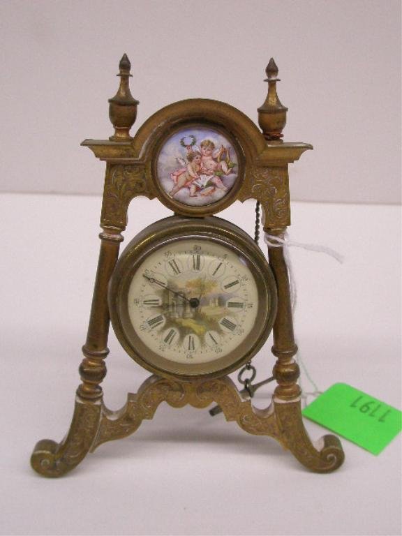 Bronze & Painted Enamel Desk Clock: Bronze & painted enamel easel form desk clock. Dial with Roman ruins painted center, crest dish w/2 cherubs, key wind, hgt 5", late 19th c.