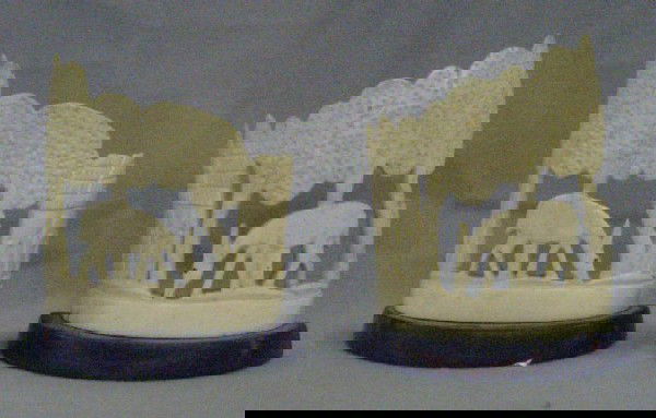 Pair African Carved Ivory Bookends: Pair African carved ivory bookends, cut out landscape carving w/ animals on wood bases, early 20th c. 4 5/8"h x 4 1/4"L. No International Shipping. [8]