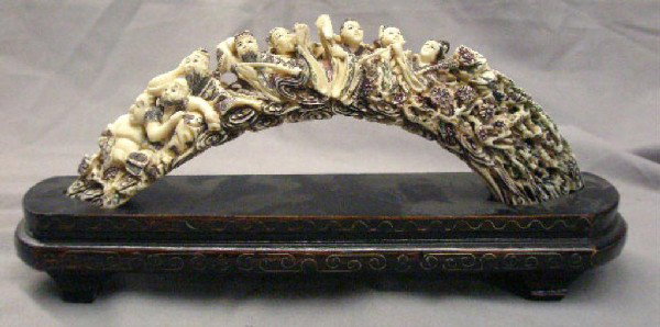Chinese Scrimshaw Ivory Tusk: Chinese Scrimshaw ivory tusk with relief carved erotic panel and etched floral & fish bordering motifs on fitted wood base, 10" length (tusk), mid 20th C. No international shipping. [39]