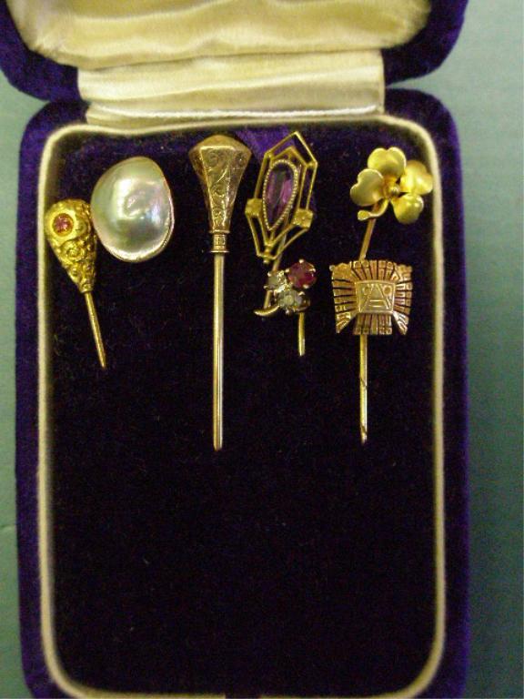 Lot Seven Assorted Gold Stick Pins: Lot of seven assorted gold stick pins, three marked 10k have Mabe pearl, red stone & amethyst, two marked 14k - 4 leaf clover & chaised hexagonal shape, 14k tested Aztec face & three stone.