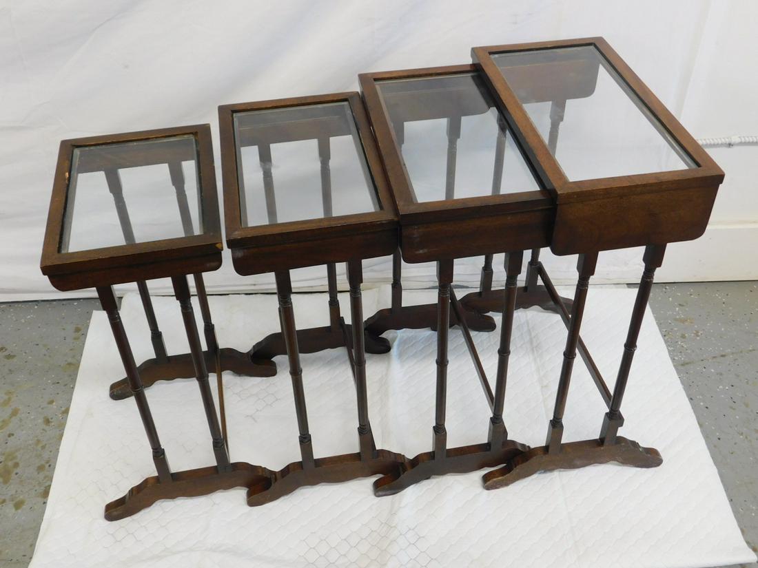 Nest of 4 Tables: Nest of four Tables, mahogany with glass tops, turned supports of shoe feet, mid 20th C, 16" x 13" x 24". CONDITION: Used, some minor scratches.