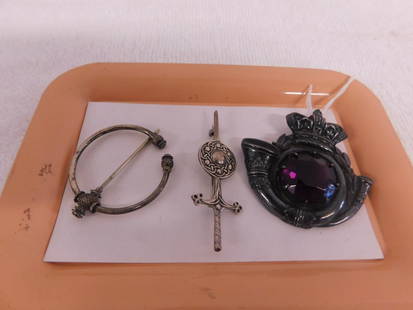 Three Sterling Celtic Pins: Three Sterling Celtic Pins includes: unmarked, tested, crown a horn kilt pin with round faceted 21mm diam., amethyst, 2 3/8"d; a sterling touch marked Viking thistle circle pin, 1 1/8"d and a sterling