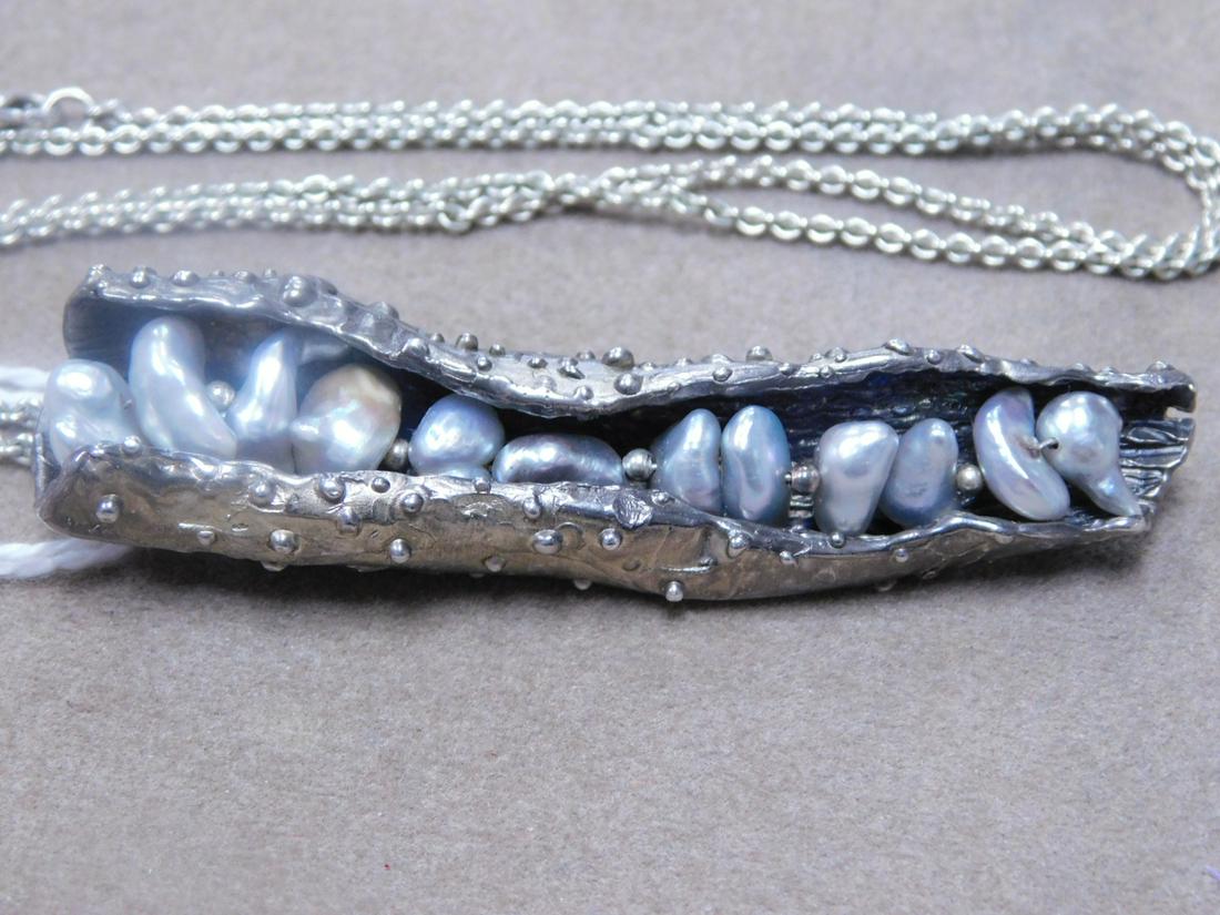 Sterling & Pearl Pea Pod Pin & Chain: Sterling and pearl pea pod brooch, sterling silver unsigned Craftsman design open pea pod with a row of twelve gray seed pearls (length 2 7/8"), along with an 18" link chain, 18 DWY. [o] CONDITION: Ve