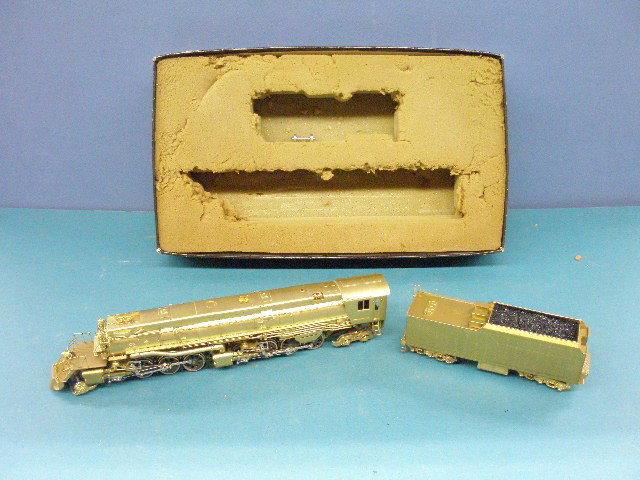 1950's HO Brass Locomotive & Tender: 1950's made in Japan HO scale brass plated Locomotive & Tender w/bottom portion of original box. Condition: Detached wheels on engine, areas of minor wear & loss on both, box portion has wear.