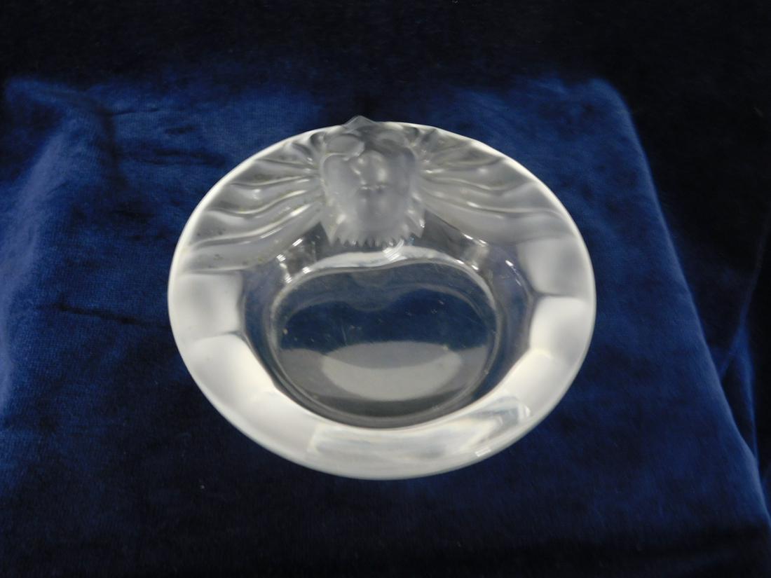 Lalique "Tete De Lion": Lalique "Tete De Lion", frosted to clear glass ashtray, 5 3/4"d. CONDITION: Used, scratches to base, needs cleaning.