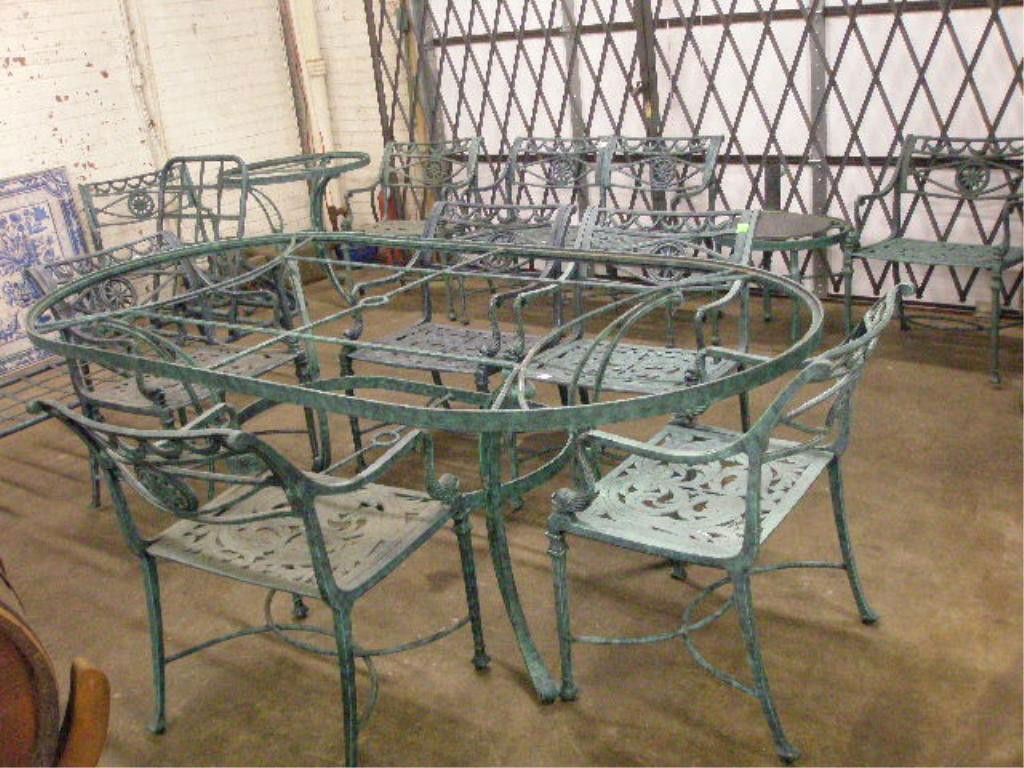 Neoclassical-Style Garden Set: 13-Piece Neoclassical-style patinated metal garden set, the ovoid glass top table with eight armchairs with dolphin arm supports; and with chaise two end tables; love seat. Condition: No issues identi