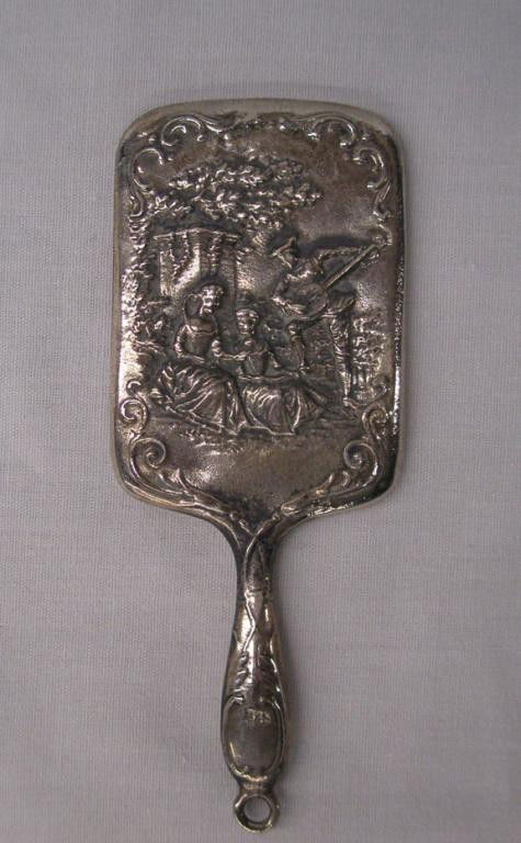925 Silver Miniature Hand Mirror: 925 silver marked 3 1/2" miniature hand mirror with embossed courting scene design. Condition: Very good with minor wear.