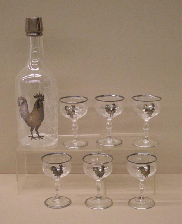 Silver Overlay Glass Decanter Set: 1930's sterling silver overlay crystal glass 7 piece decanter set, 10 1/2" decanter with deep gravic cut floral design, six 4" footed glasses, silver overlay rooster & top on decanter, silver overlay
